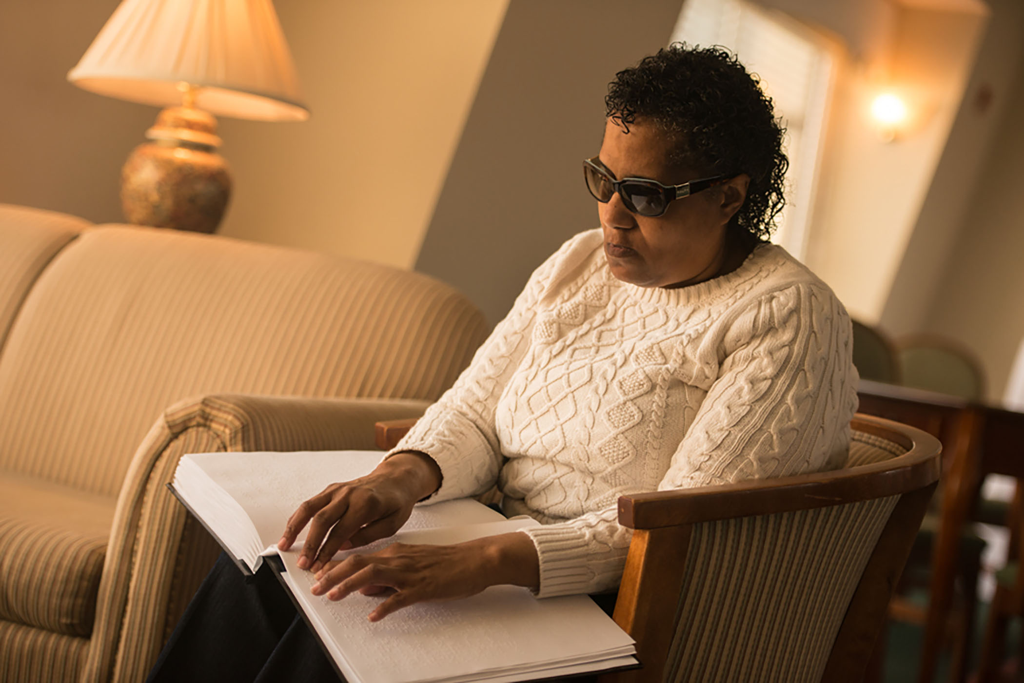 Woman Sitting and Reading Braille